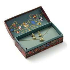 Brillo de Quidditch listo para regalar: el set Snitch Dorada – collar + pendientes llega en una caja recuerdo decorada con escudos de Hogwarts e incluye un collar de 40 cm con prolongador de 5 cm y pendientes huggie de 1 cm de ancho