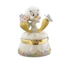 Un estallido de ternura primaveral cobra forma en esta delicada cajita de porcelana protagonizada por el simpático Tweety, que sostiene un ramo de flores mientras observa maravillado a una mariposa posada sobre su patita. 