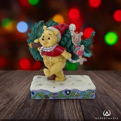 Winnie the Pooh y Piglet se adentran en el espíritu navideño en esta encantadora escena diseñada por Jim Shore. Pooh luce un sombrero de Santa decorado con acebo y detalles de rosemaling 