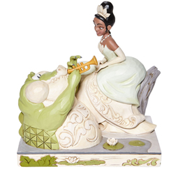 Figura de la Princesa Tiana con Louie del clásico Disney “Tiana y el Sapo” elaborada por el artista Jim Shore. Con esta figura con unas dimensiones aproximadas de 19 x 18,5 x  12 cm.