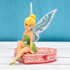 Preciosa figura de Campanilla sentada en el corazón con una altura aproximada de 13 cm., disfruta del hada más famosa de la factoría Disney rememorando una de las escenas de la película de Peter Pan.