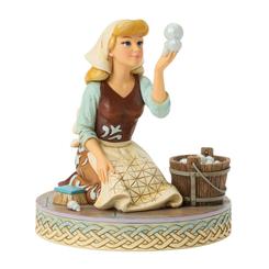 El brillo efímero de una burbuja ilumina la fuerza interior de Cenicienta en esta delicada escena de Jim Shore, donde su espíritu inquebrantable se refleja mientras, vestida de sirvienta