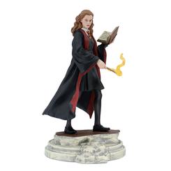 Determinación y magia académica en plena madurez: Hermione Granger YR6 luce túnica de Gryffindor, libro abierto y varita con efecto de llama translúcida, en una pose firme sobre base texturizada que recuerda a la piedra de Hogwarts