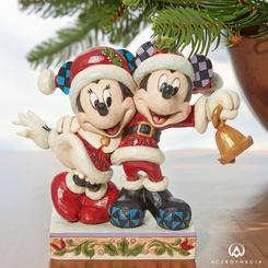 ¡Llega la Navidad y con ella una de las creaciones más elegantes de Jim Shore! Esta impresionante figura presenta a los personajes originales de Disney, Mickey y Minnie Mouse, con unos adorables trajes de Santa con orejas de patchwork y amplias sonrisas.