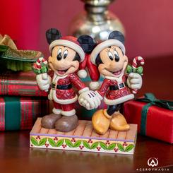 Mickey y Minnie Mouse iluminan las fiestas en esta encantadora escena navideña diseñada por Jim Shore. Vestidos con trajes de Santa que exhiben intrincados patrones de rosemaling