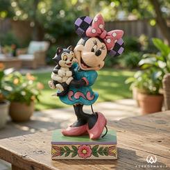 La figura Disney Traditions Minnie y Fígaro parece capturar un instante robado de ternura clásica, con Minnie abrazando a su inseparable gatito como si acabara de salir de una escena animada. Esta figura Disney Traditions Minnie y Fígaro