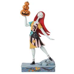 La magia de Halloween cobra vida con esta encantadora pieza de Jim Shore que presenta a Sally de El extraño mundo de Jack. Con su vestido de encantador patchwork y diseños de rosemaling,