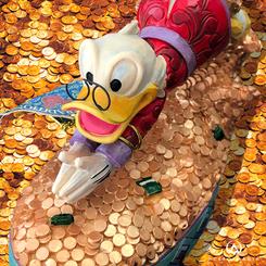 Figura del Tío Gilito nadando y buceando en su montaña de dinero, esta divertida figura tiene una altura aproximada de 12,5 cm., se ha mezclado la magia de las figuras de Walt Disney.
