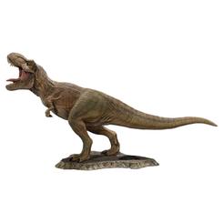 La estatua Tyrannosaurus Rex Jurassic World impone antes de mirar sus detalles. La boca abierta, la postura en pleno rugido y la base rocosa convierten esta réplica coleccionable de T-Rex en una pieza con presencia inmediata.
