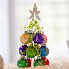 ¡Prepárate para vivir la magia de la temporada invernal con este encantador Árbol de Navidad de vidrio inspirado en el querido clásico de Disney, Frozen! Con una altura de alrededor de 15 cm, 