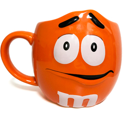 Preciosa taza Deluxe de M&M Naranja. Disfruta de tu bebida preferida en esta simpática taza está realizada en cerámica con una capacidad aproximada de 0,68 litros, y con unas dimensiones aproximadas de 16 x 11.5 cm.